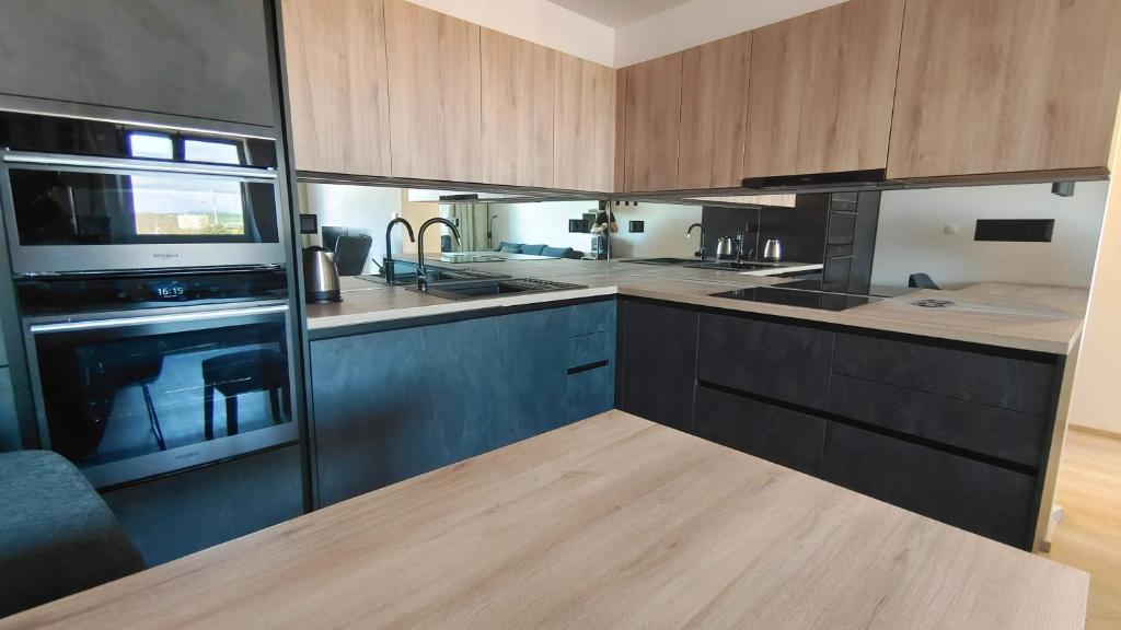 a kitchen with wooden cabinets and a stove top oven at Stellaria apartment in Poprad