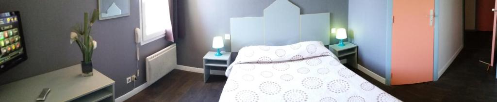 een slaapkamer met een bed en 2 tafels met kaarsen bij Hôtel Motelia in Moissy-Cramayel