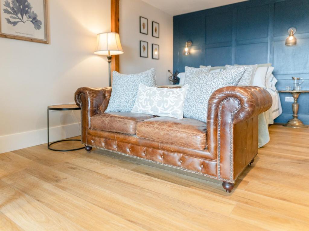 un sofá de cuero marrón en una habitación con cama en Cuillin Studio - Ukc6562, en Mallaig