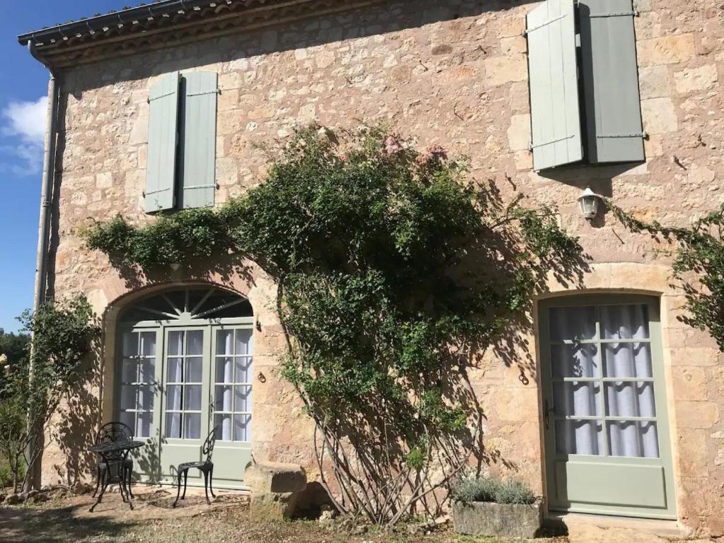 een gebouw met twee ramen en een boom ervoor bij Domaine de la Durantie Duplex Vieux Chateau in Castelnau-de-Montmiral