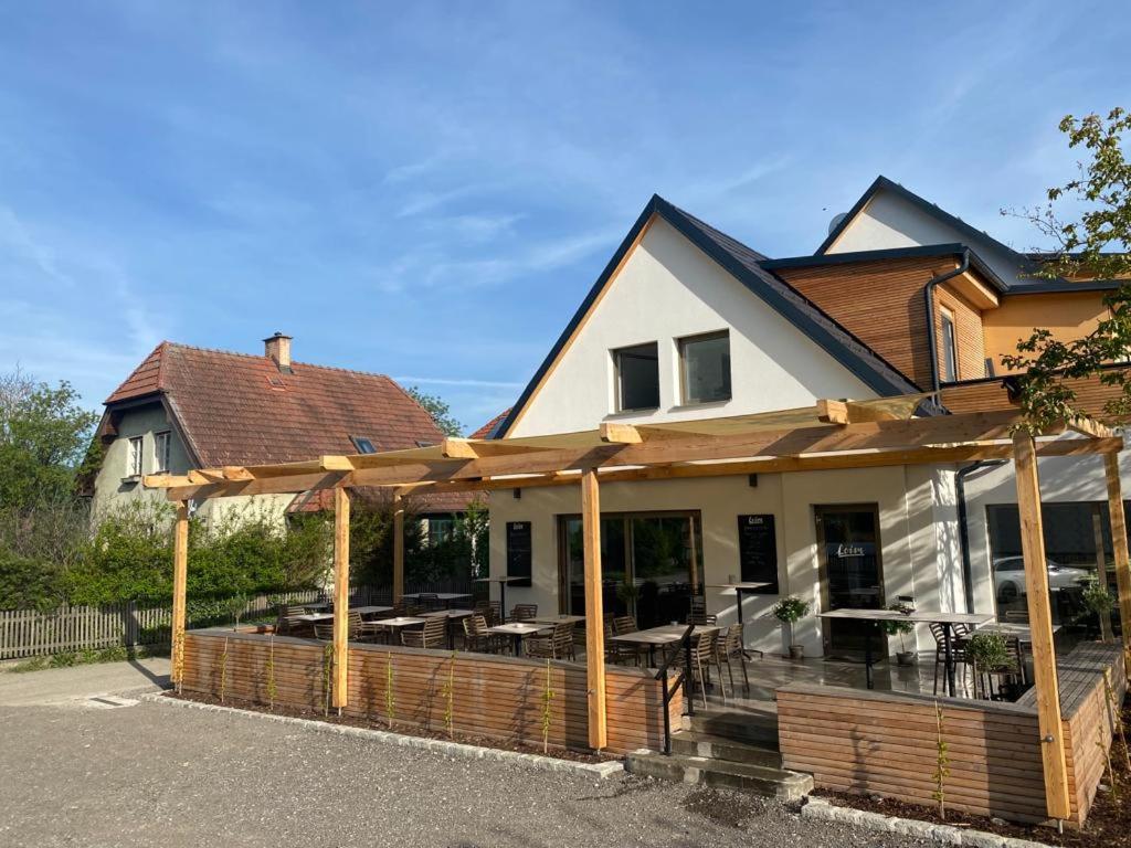 a house with an outdoor deck with wooden posts at Apartments Loim Lodge in Dürnstein