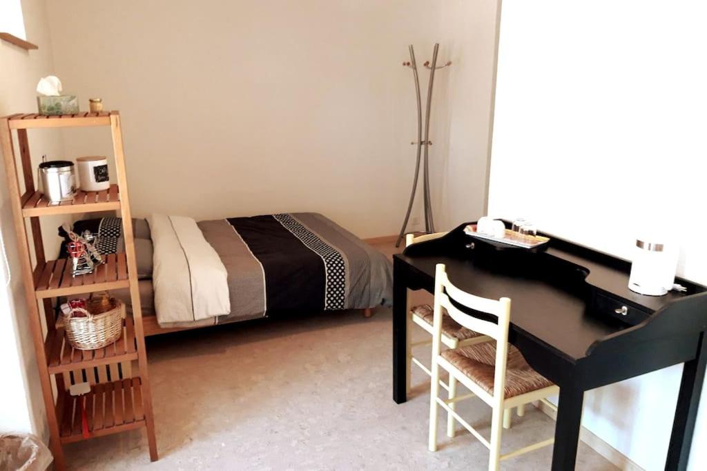 a bedroom with a desk and a bed and a desk and chair at L'Annexe in Môtiers