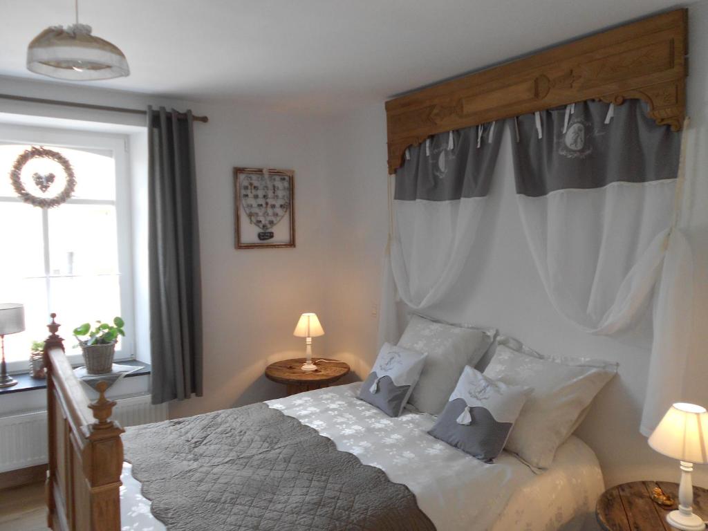 Un dormitorio con una cama grande y una ventana en La Belly d'or, en Izier