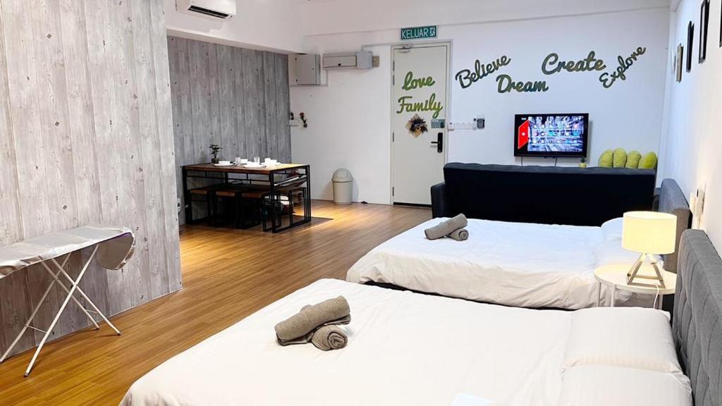 een kamer met 2 bedden en een tv aan de muur bij S1 Cozy Home Sunway Geo 2Queens Sunway Medical Centre in Petaling Jaya