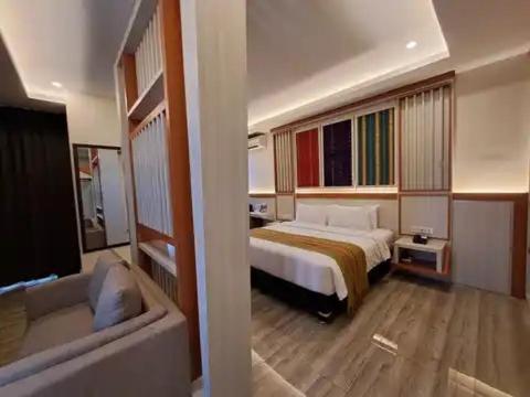 Hotel Simfony Alor في Kalabahi: غرفة في الفندق مع سرير وحوض استحمام