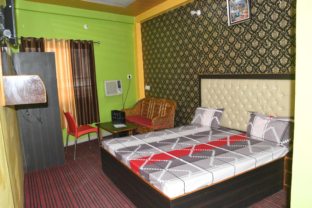 1 dormitorio con cama y pared verde en Hotel Mountain View And Rooftop Restaurant, en Pithorāgarh