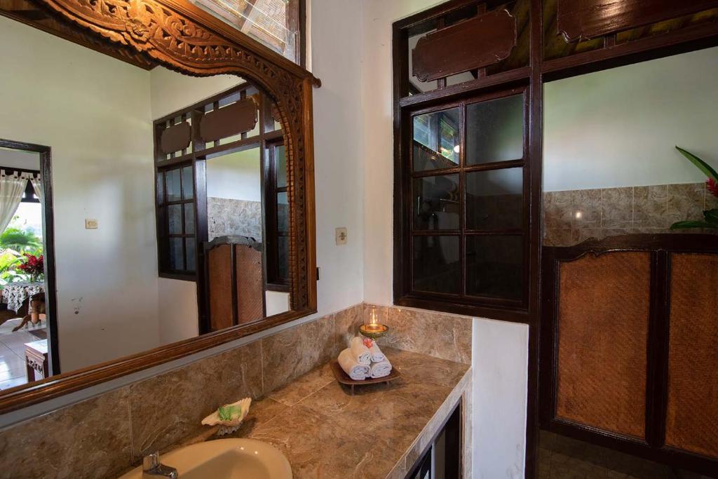 a bathroom with a sink and a mirror at Cabé Bali in Jasri