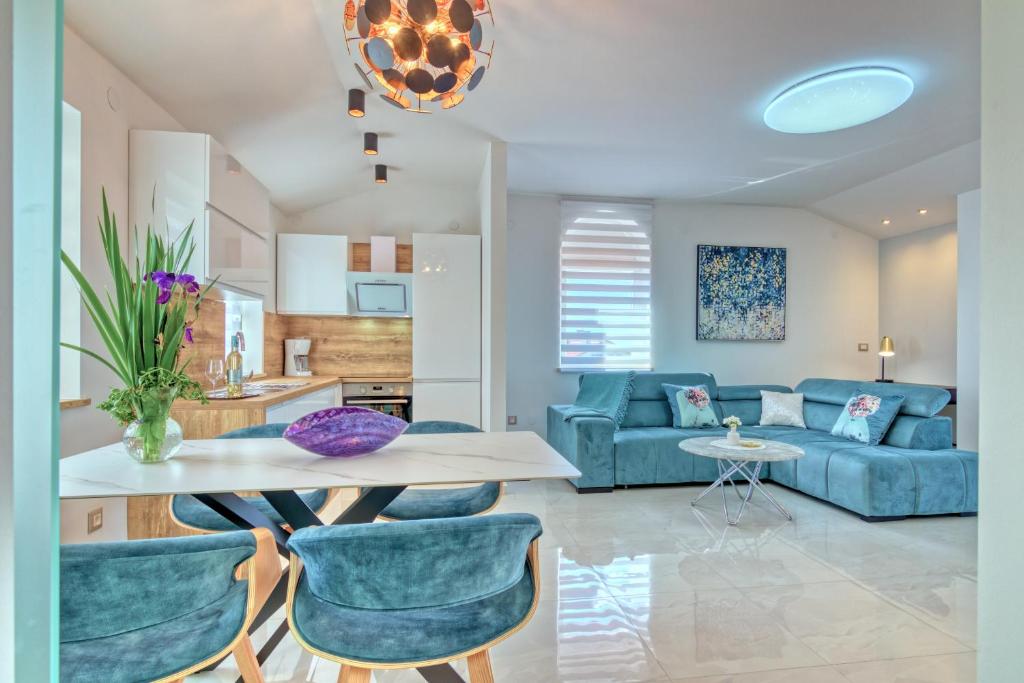 a living room with a blue couch and a table at Apartments Birimac in Pula