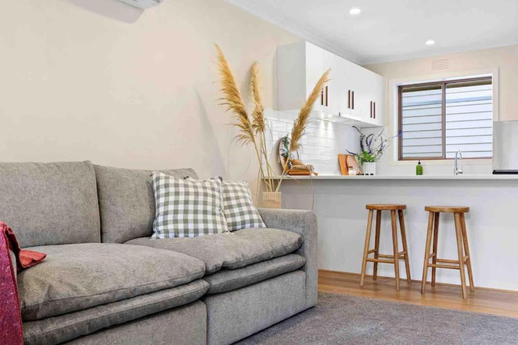 a living room with a couch and a kitchen at Terra Mare in Geelong West