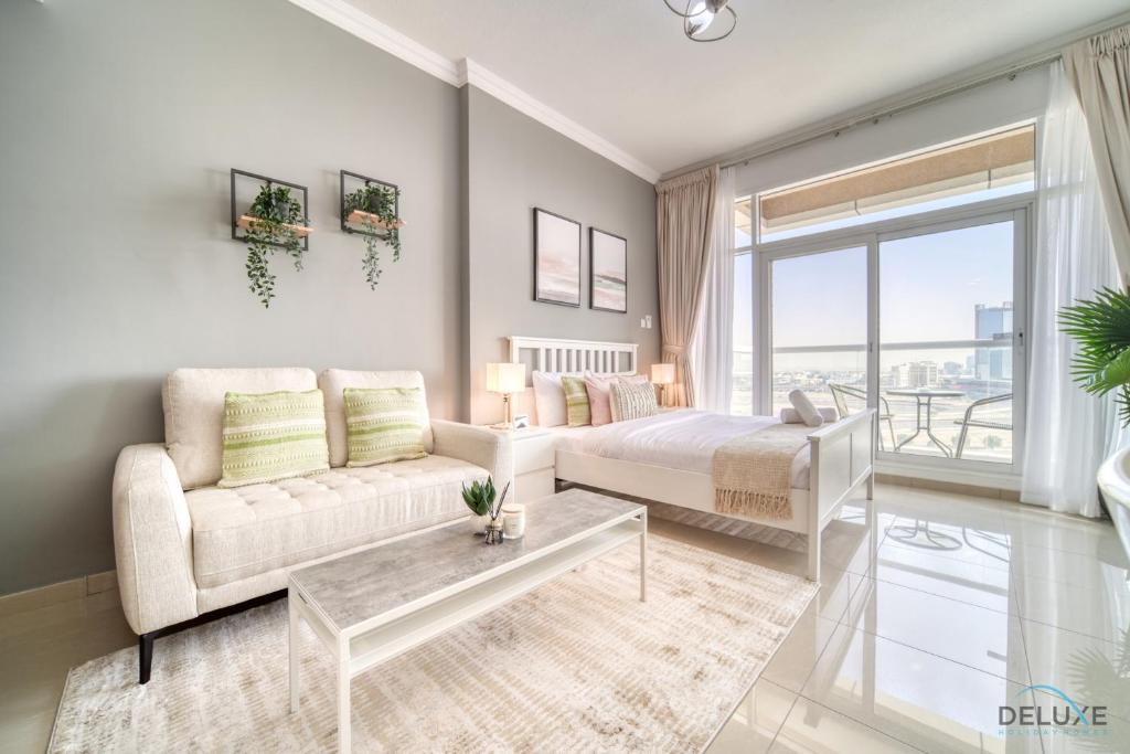 a living room with a bed and a couch at Elegant Studio at Al Madar Siraj Tower 1 Al Barsha South by Deluxe Holiday Homes in Dubai
