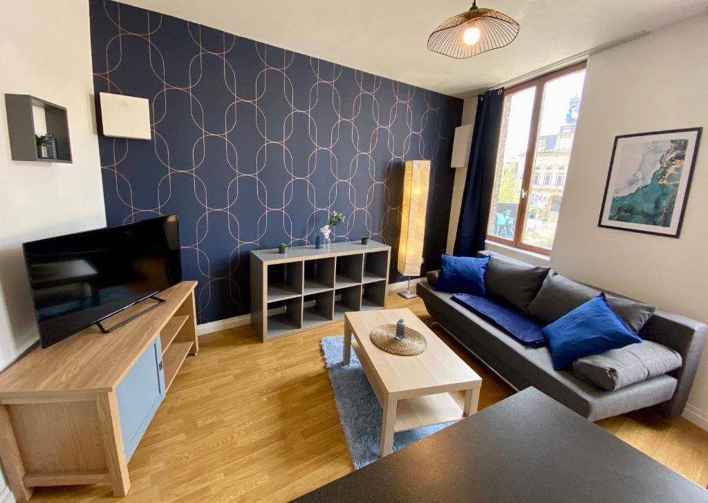ein Wohnzimmer mit einem Sofa und einem TV in der Unterkunft La Vague Dorée - Hyper-Centre - 15 min de Rouen in Barentin