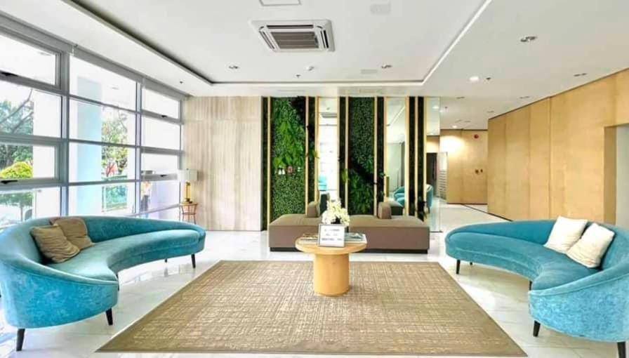 a living room with two blue couches and a table at Studio unit at The Loop in Cagayan de Oro