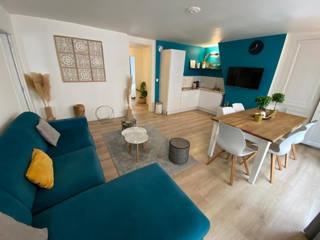 uma sala de estar com um sofá azul e uma mesa em Le Cocon de Jeanne em Rouen