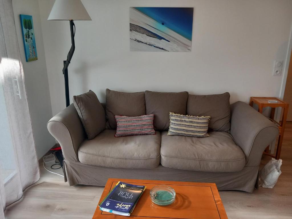 Sofá marrón en la sala de estar con mesa en Appartement 4 personnes à Arradon, en Arradon