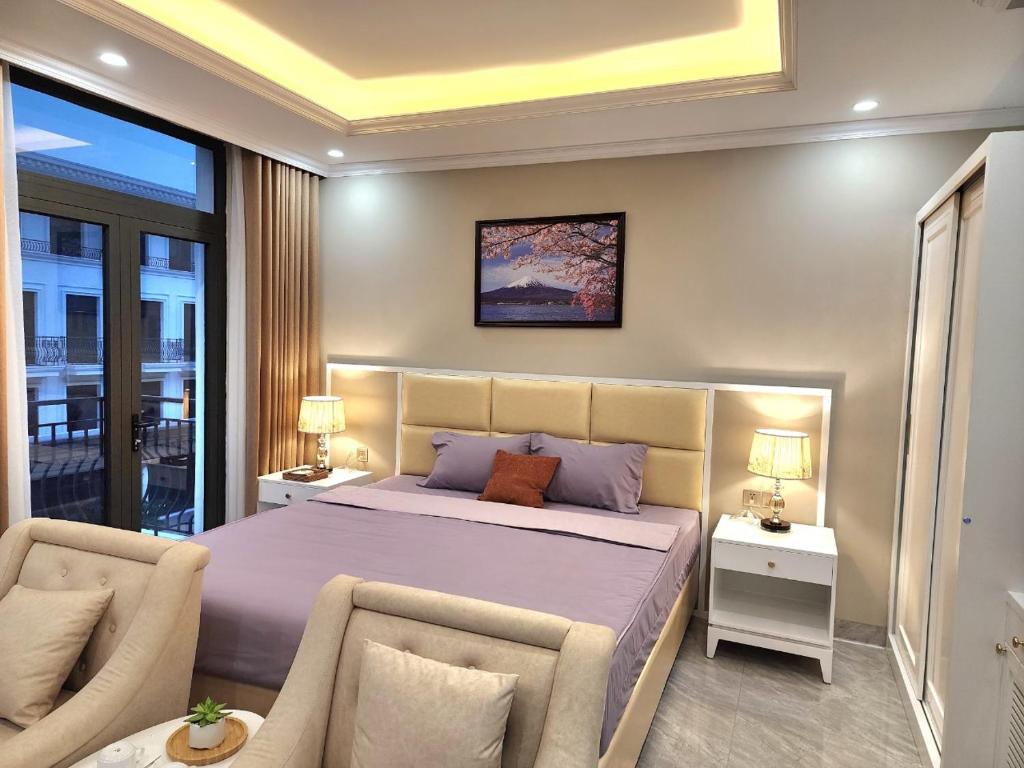 um quarto com uma cama grande e 2 cadeiras em Sakura Homestay Cao cấp T4 em Gia Lâm Pho