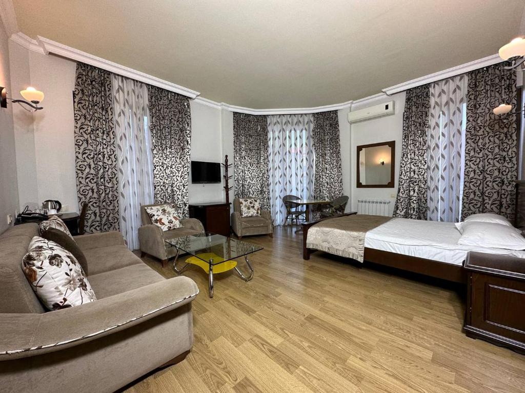 a bedroom with a bed and a couch in a room at Eiffel Hotel in Batumi
