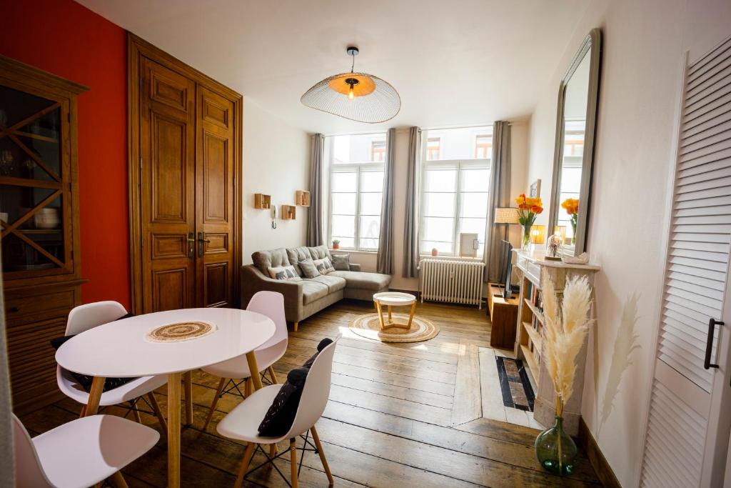 salon z białym stołem i krzesłami w obiekcie Gîte La Petite Ourse w mieście Andenne