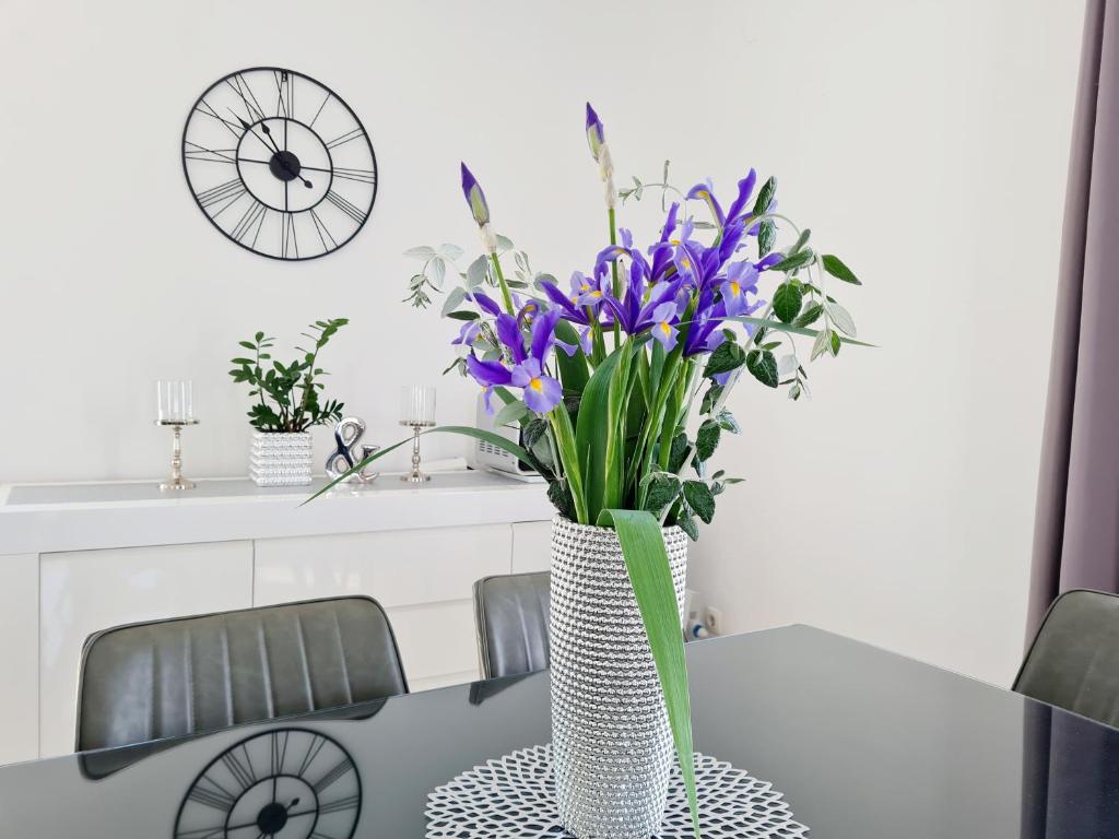 wazon wypełniony fioletowymi kwiatami na stole w obiekcie Apartment in Murter w mieście Murter