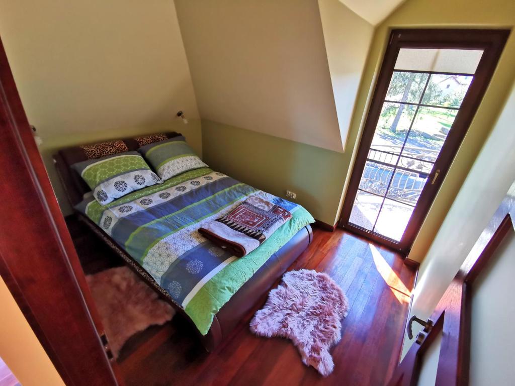 a bedroom with a bed in a room with a window at Domek wypoczynkowy Zielonka z JACUZZI in Szczytno