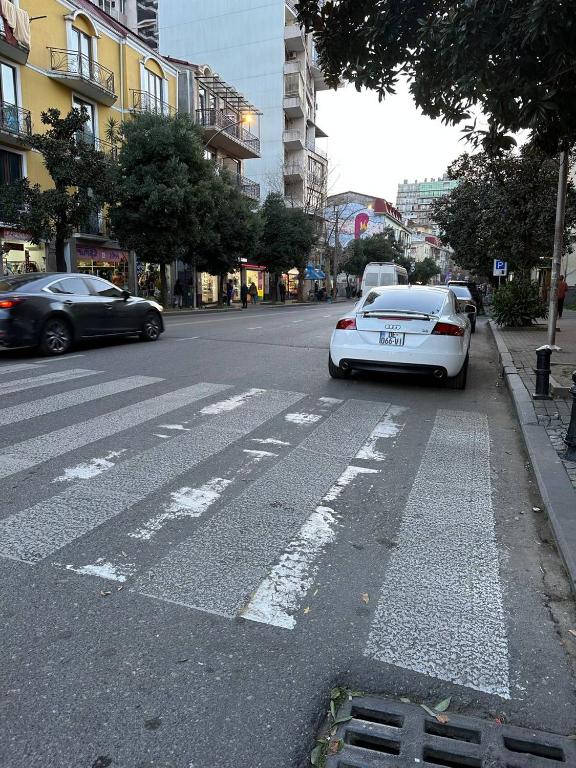 a white car parked on the side of a street at Eiffel Hotel in Batumi