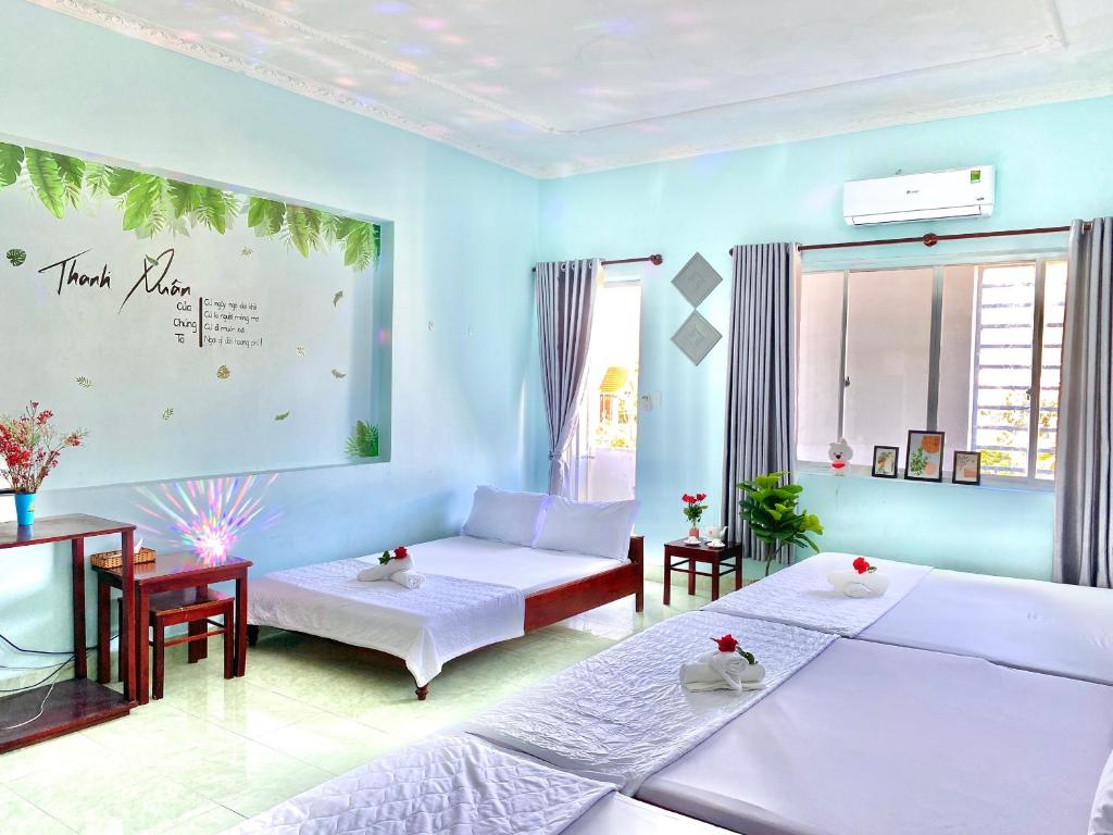 a blue room with two beds and a couch at THANH THẢO MOTEL in Vung Tau