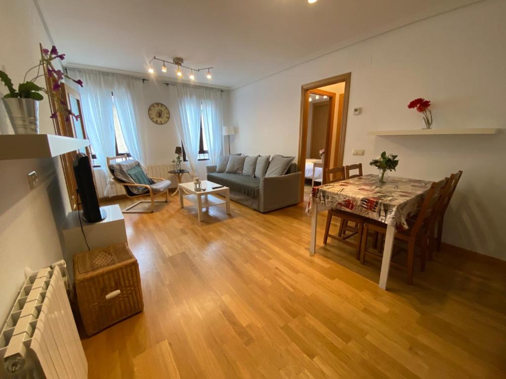 a living room with a table and a couch at Apartamentos Alfonso XIII in La Granja de San Ildefonso