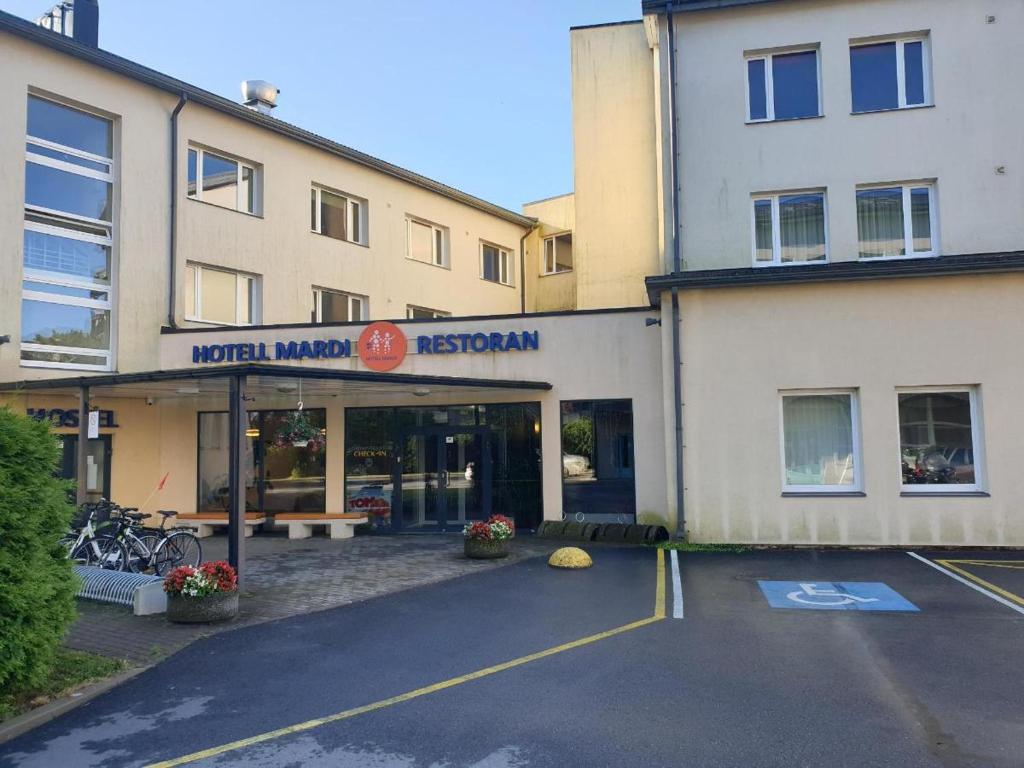 a parking lot in front of a building at Mardi Hotel in Kuressaare