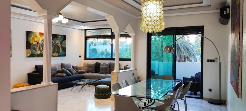uma sala de estar com uma mesa de vidro e um sofá em APPARTEMENTS NIA CONFORT, Plein centre ville, avec TERRASSE em Fez