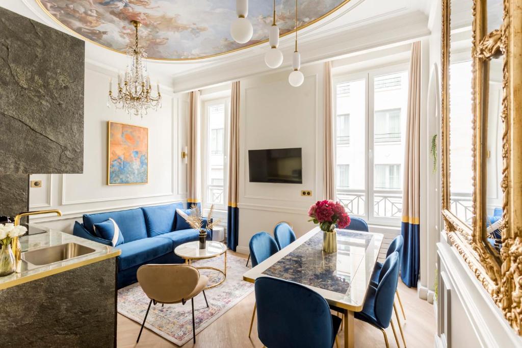 ein Wohnzimmer mit einem blauen Sofa und einem Tisch in der Unterkunft Luxury 2 Bedroom 1 Bathroom - Louvre Museum & Opera in Paris