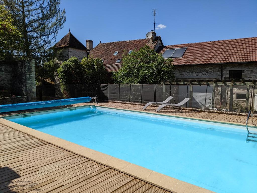 una piscina con terraza de madera y una casa en Le Figuier, Large house with pool, gym & separate gite, en Saint-Ythaire