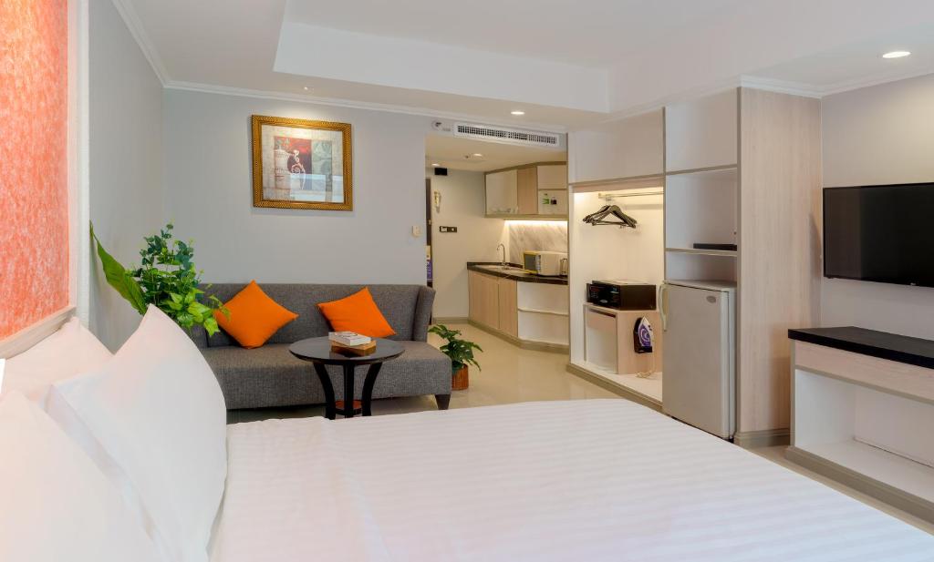 a hotel room with a bed and a living room at FuramaXclusive Sukhumvit in Bangkok