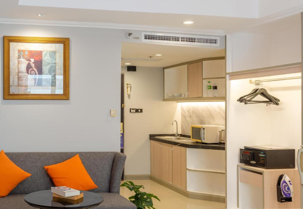 a living room with a couch and a kitchen at FuramaXclusive Sukhumvit in Bangkok