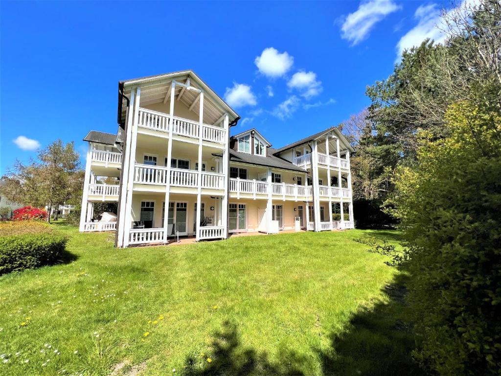 a large white house with a large yard at Dünenpark 090 in Binz