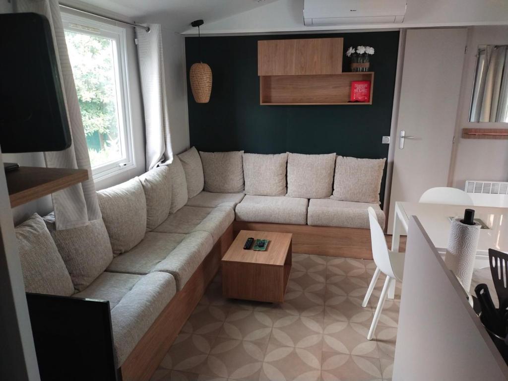 a living room with a couch and a table at MOBIL HOME LE BIENVENUE 3 CH VALRAS PLAGE in Valras-Plage
