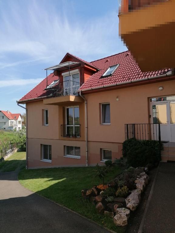 een huis met een rood dak en een tuin bij Zita Apartman in Eger