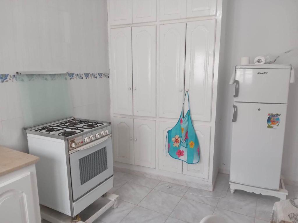 eine Küche mit einem Herd und einem Kühlschrank in der Unterkunft Confortable Maisonnette prés de la plage à Dar el Alouch in Kelibia