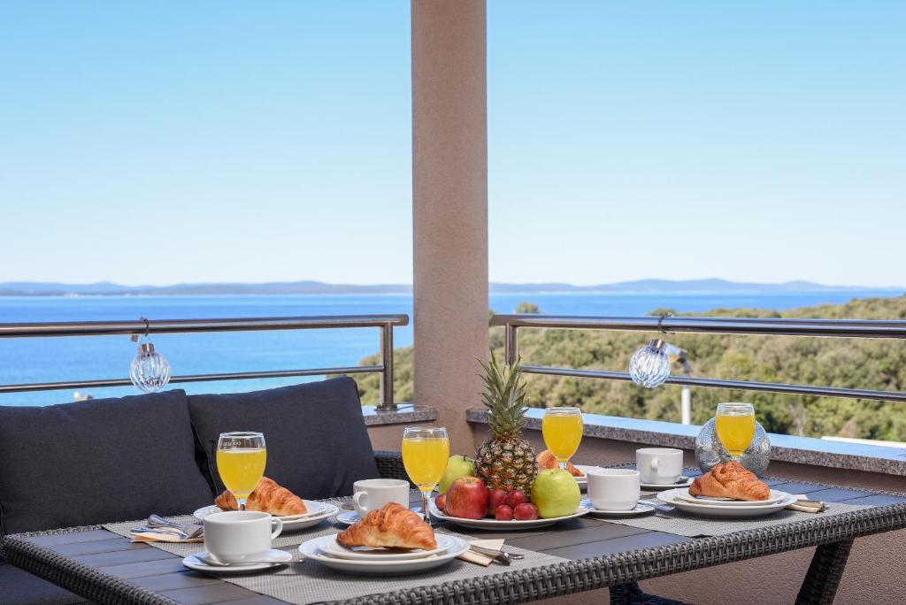 a table with food and fruit on a balcony at Sunset Beach Suites in Kožino