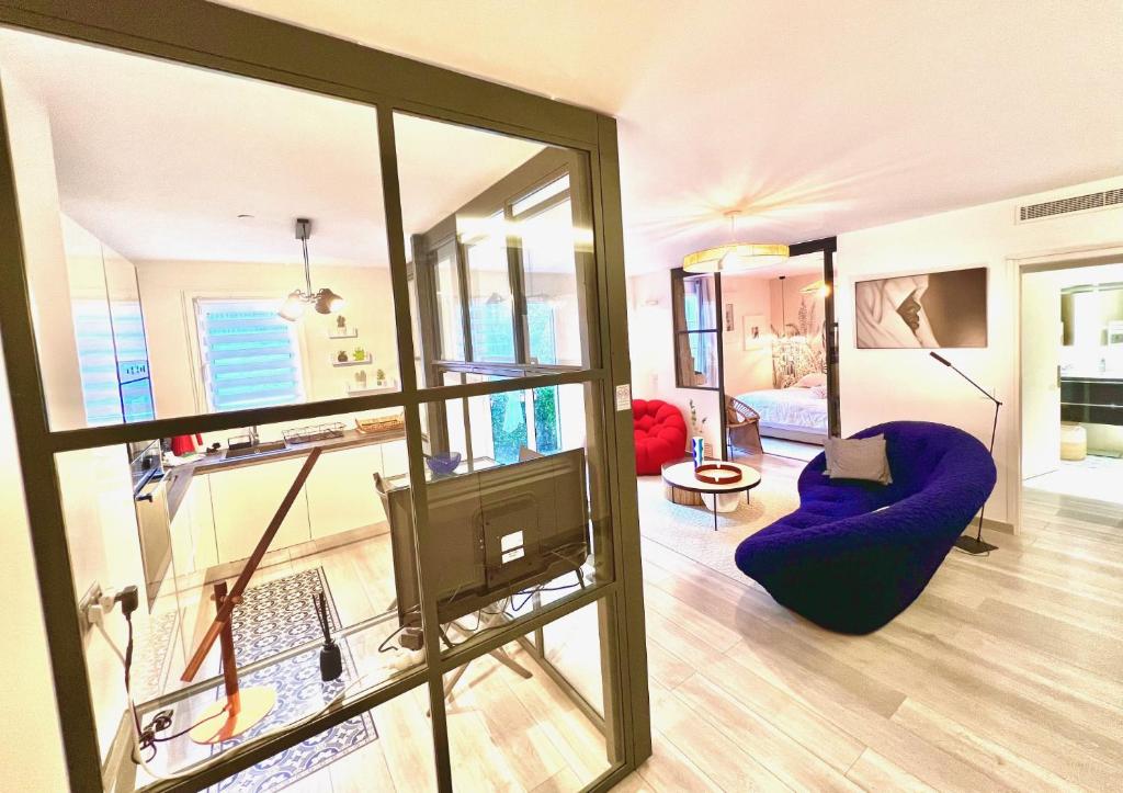 ein Wohnzimmer mit einem blauen Stuhl und einem TV in der Unterkunft ApartHotel Riviera - BBB Vieille Ville - Splendide appartement de 3p AC avec Terrasse - LOFT PROVIDENCE in Nizza