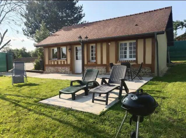 une maison avec 2 chaises et un barbecue dans la cour dans l'établissement Gîtes les Deux Vallées, 