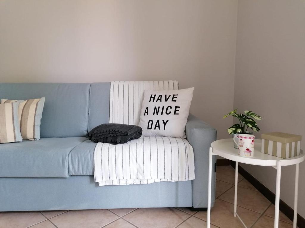a blue couch with a nice day pillow on it at Casa Martin apt piano terra By Case al Lago in Peschiera del Garda