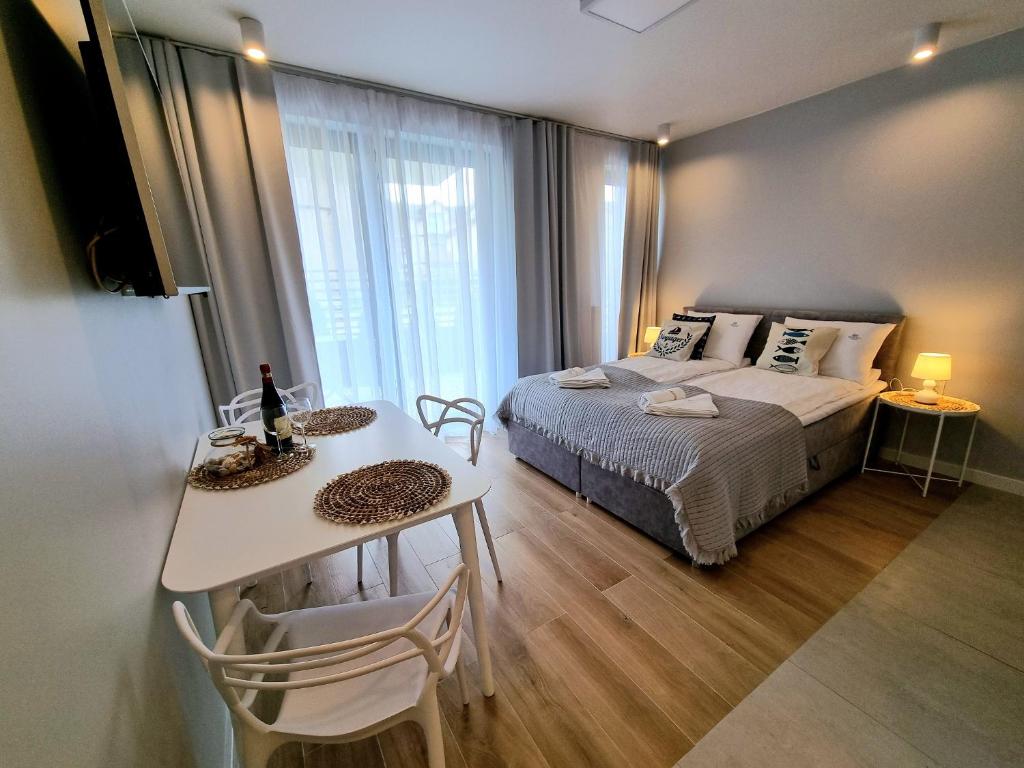 um pequeno quarto com uma cama, uma mesa e uma mesa; em Baltic Soul Villa em Międzyzdroje