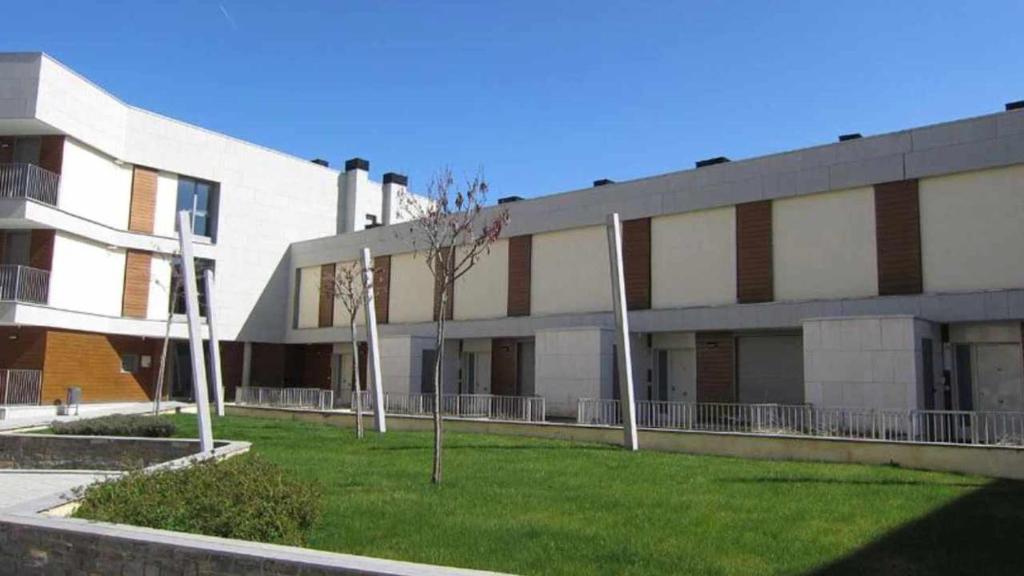 un edificio con un patio de césped delante de él en Chalet en Las Margas Golf Club de Latas WOWRURAL, en Sabiñánigo