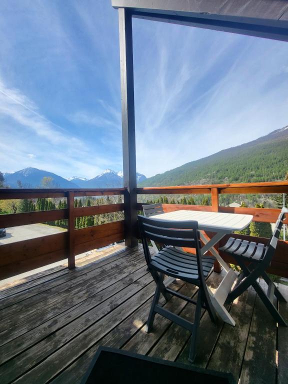 - une table et des chaises sur une terrasse avec vue dans l'établissement Charmant T2 proche Serre Chevalier Vallée 4 personnes, à Briançon