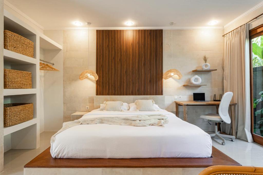 Schlafzimmer mit einem großen weißen Bett und einem Schreibtisch in der Unterkunft Designer Studio Emy Sanur in Sanur