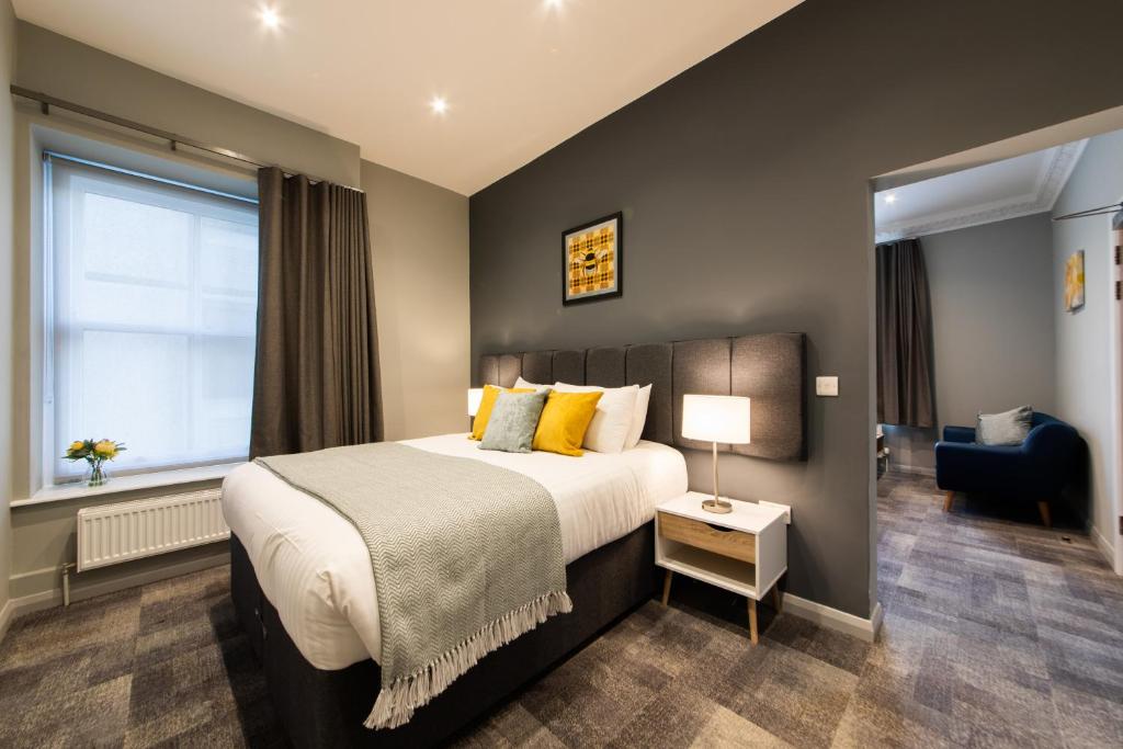a bedroom with a large bed and a window at The Spires Serviced Apartments Cardiff in Cardiff