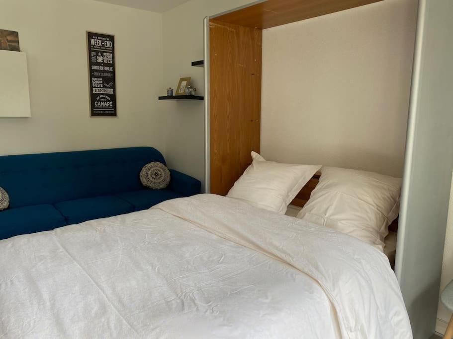 - une chambre avec un lit et un canapé bleu dans l'établissement Trimaran Studio 10 mètres de la plage avec balcon/terrasse, à Mers-les-Bains