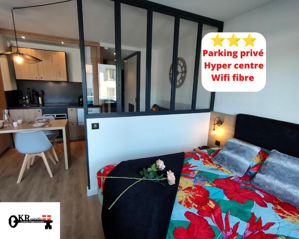 1 dormitorio con 1 cama y cocina con mesa en Magnifique 3 étoiles en hyper centre avec place privée en Aix-les-Bains