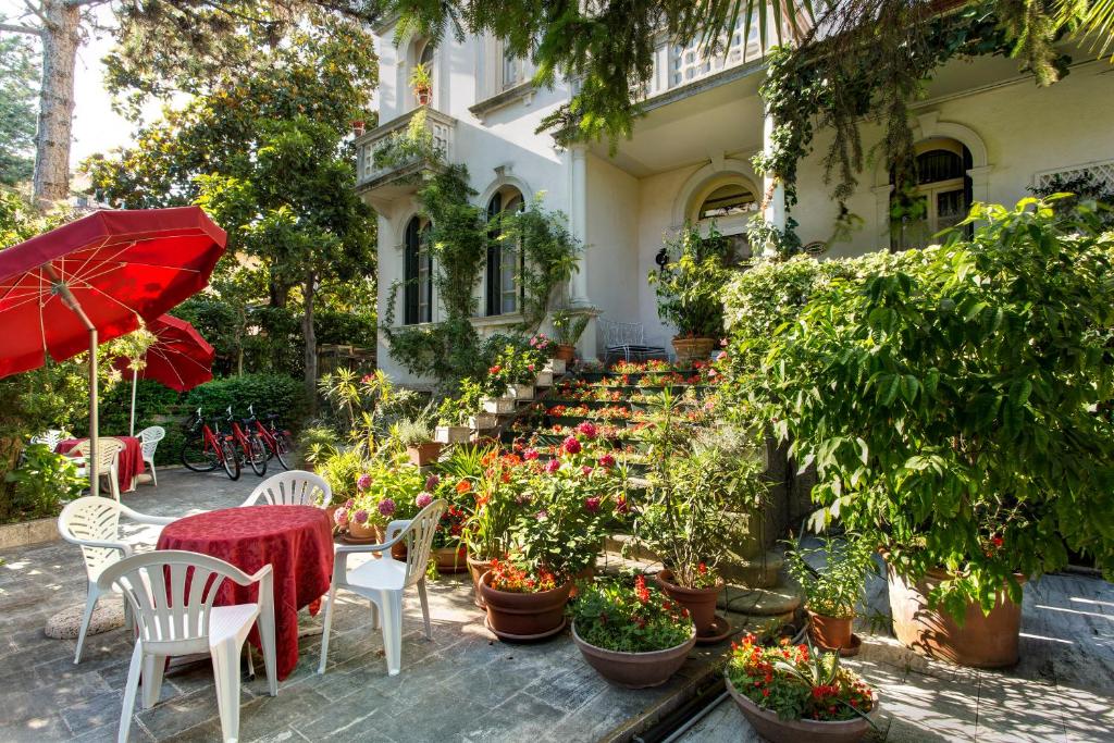 a patio with a table and chairs and potted plants at Hotel Biasutti in Venice-Lido
