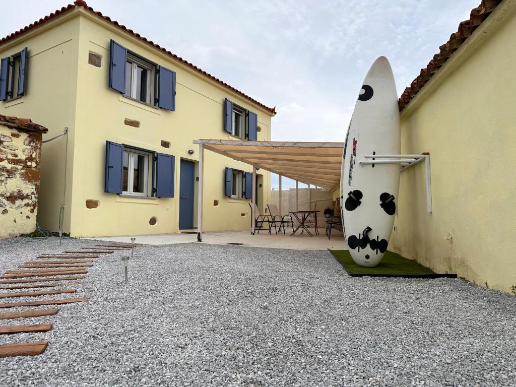 a surfboard leaning against a building with a house at Surf-themed stone house at Kalliopi 2 in Kalliópi