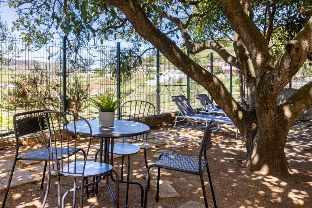 una mesa y sillas sentadas bajo un árbol en Tegueste Charming House en Tegueste